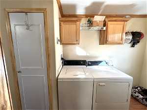 Laundry room with washer hookup, cabinets, independent washer and dryer, and wood-type flooring