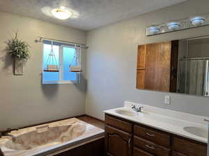 Bathroom featuring a textured ceiling and double sink vanity