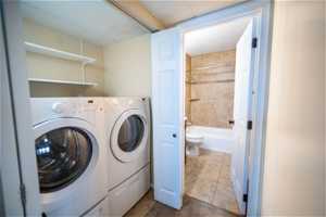 Laundry area with independent washer and dryer and tile floors
