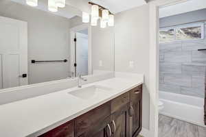 Bathroom with toilet, vanity with extensive cabinet space, and tile flooring