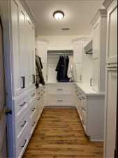 Walk in closet with light wood-type flooring