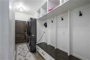 Mudroom featuring stacked washer / drying machine and hardwood / wood-style flooring