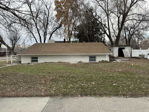 View of side of property featuring a yard and an outdoor structure