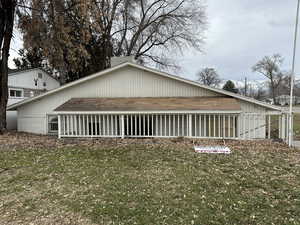 View of side of property with a sunroom and a lawn