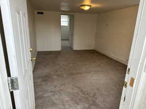 Empty room featuring dark colored carpet