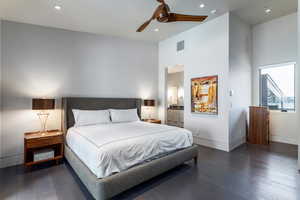 Bedroom featuring wood finished floors, baseboards, ensuite bath, recessed lighting, and a ceiling fan
