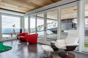 Sunroom / solarium featuring wood ceiling, plenty of natural light, and wood finished floors