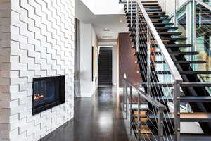 Staircase featuring a glass covered fireplace and recessed lighting
