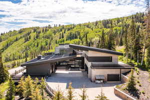 View of front of home with a view of trees and driveway