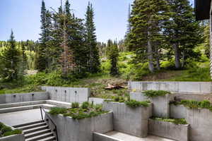 View of patio / terrace featuring a view of trees and stairway