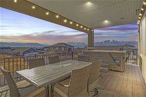Deck at dusk featuring a mountain view, wall/ceiling surround sound speakers