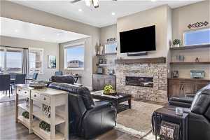 Great room with electric fireplace, dark hardwood / wood-style floors, and ceiling fan