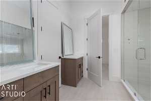 Bathroom featuring tile floors, double vanity, and an enclosed shower