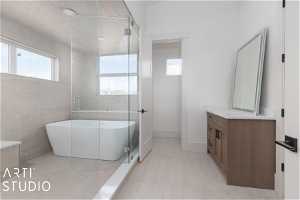 Bathroom with tile floors, independent shower and bath, a wealth of natural light, and vanity with extensive cabinet space