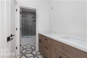 Bathroom featuring tile floors, double sink vanity, and enclosed tub / shower combo
