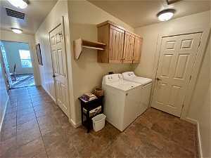 Washroom featuring washer hookup, cabinets, separate washer and dryer, and dark tile floors