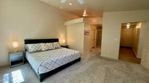 Carpeted bedroom featuring lofted ceiling and ceiling fan