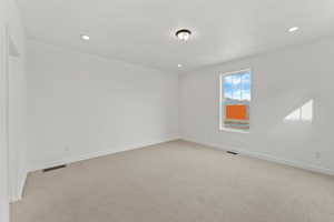 Empty room featuring light carpet