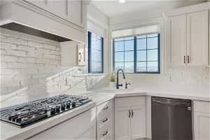 Kitchen featuring sink, white cabinetry, tasteful backsplash, and stainless steel appliances