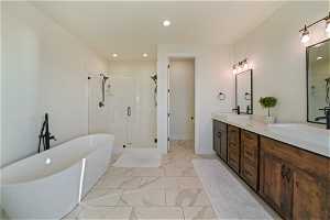 Bathroom featuring tile flooring, large vanity, shower with separate bathtub, and double sink