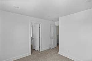 Bedroom 2 with light colored carpet and walk in closet