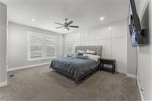 Large Carpeted Primary bedroom featuring a textured ceiling and ceiling fan