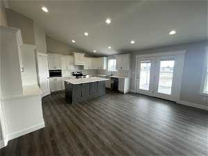 Kitchen with white cabinetry, a kitchen island, tasteful backsplash, electric stove, and dark hardwood / wood-style floors