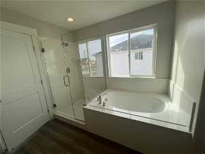 Bathroom with independent shower and bath and hardwood / wood-style flooring