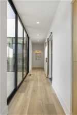Corridor with light hardwood / wood-style flooring and a barn door