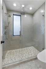 Bathroom with tile floors, toilet, and a shower with door