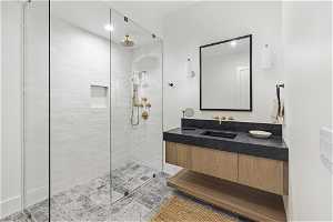 Bathroom with tile flooring, vanity, and tiled shower