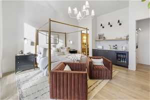 Bedroom featuring an inviting chandelier, light hardwood / wood-style floors, and beverage cooler
