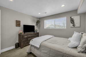 Carpeted bedroom featuring a textured ceiling