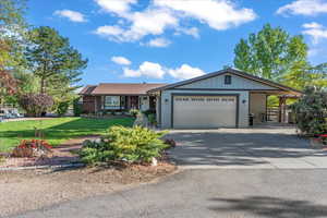 Ranch-style home featuring a garage and a front yard