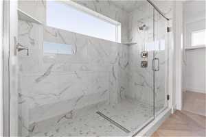Bathroom featuring parquet flooring and a shower with door
