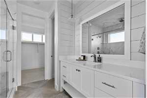 Bathroom featuring vanity with extensive cabinet space, parquet floors, and an enclosed shower