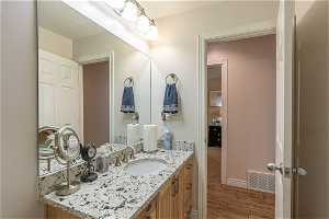 Bathroom with oversized vanity and hardwood / wood-style floors