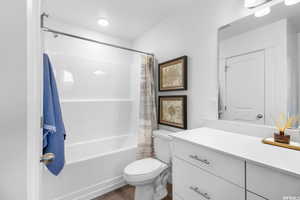 Full bathroom featuring wood-type flooring, toilet, vanity, and shower / bath combo *Bathroom includes dual sinks, this photo is a previously built home that did not include the dual sink*