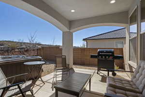 View of patio with grilling area and a hot tub