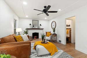 Living room with light hardwood / wood-style flooring and ceiling fan