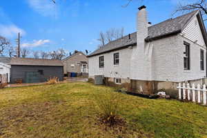 Back of house with a lawn and central AC unit