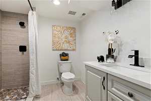 Bathroom featuring vanity, toilet, and a shower with curtain