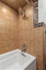 Bathroom featuring tile walls and tiled shower / bath combo