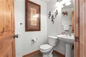 Bathroom featuring sink, toilet, and tile flooring