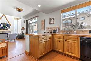 Kitchen featuring tasteful backsplash, dishwasher, sink, and light hardwood / wood-style floors