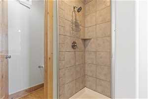 Bathroom with a tile shower and hardwood / wood-style floors