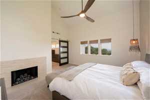 Master bedroom suite with high vaulted ceiling, fireplace, and ceiling fan