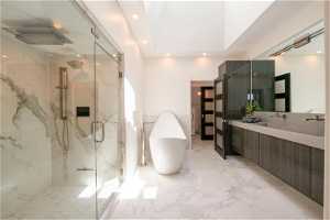 Master bath with separate deep soak tub and programmable shower, a large skylight ceiling, and double sink vanity