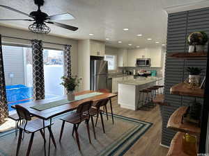 Dining space featuring light hardwood / wood-style flooring, a textured ceiling, and ceiling fan