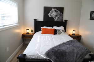 Bedroom with multiple windows and dark hardwood / wood-style flooring